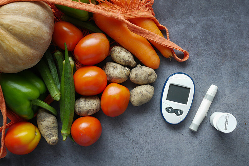 Aparato para la diabetes junto a verdura y fruta (Foto: envato)